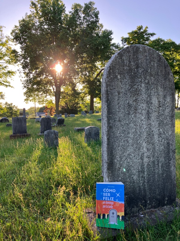 Un libro de humor junto a una lápida en el cementerio